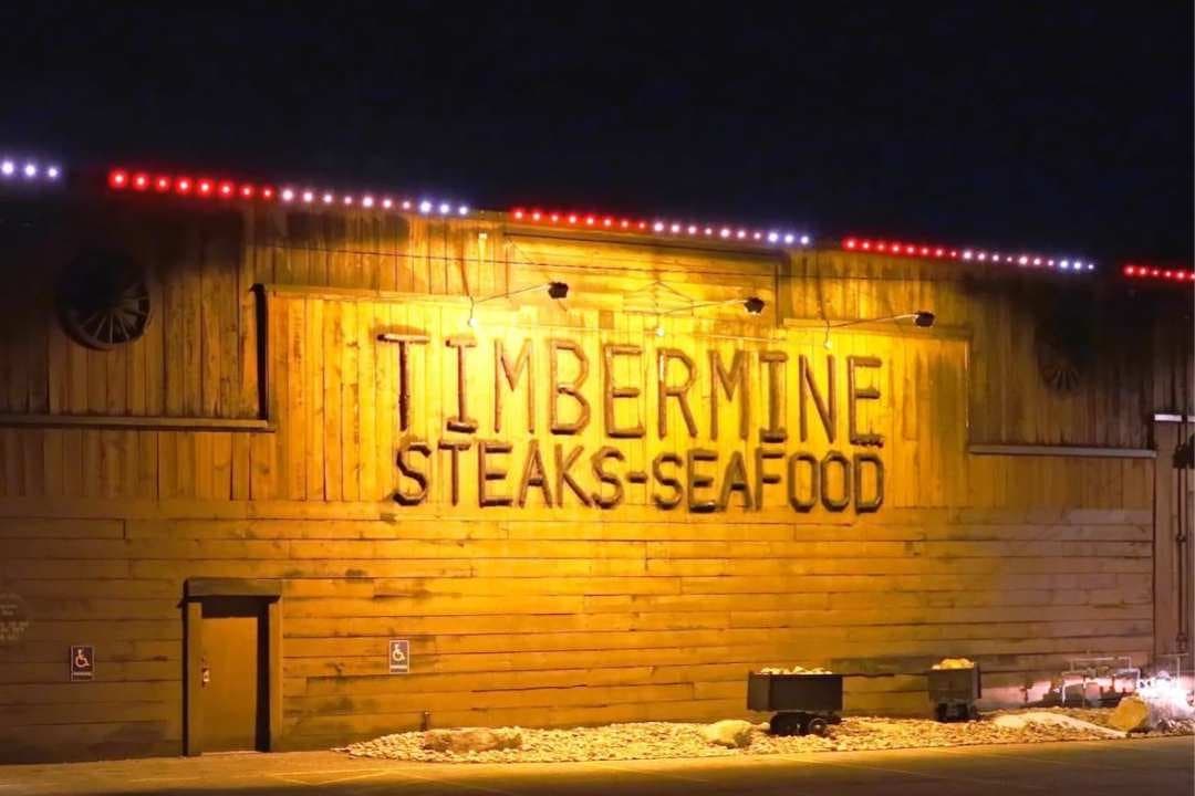 A restaurant lit warmly at night, its roofline outlined in light.