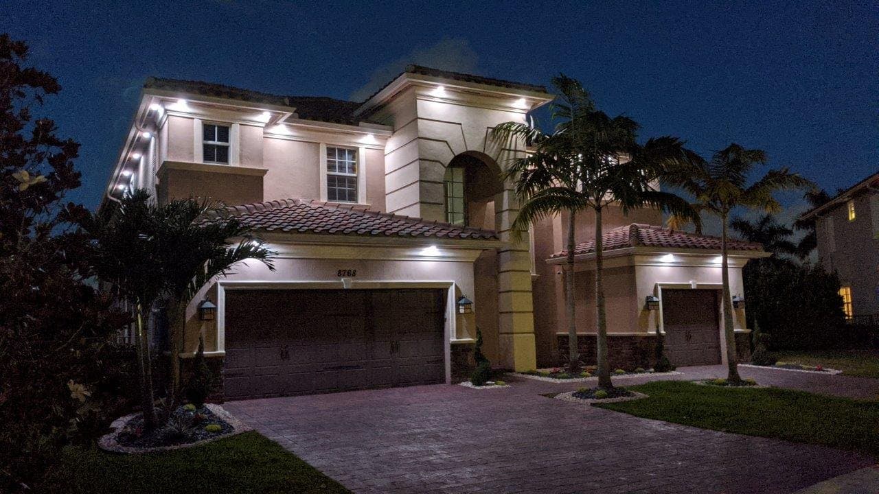 Warm white architectural lighting illuminating a two-story home.