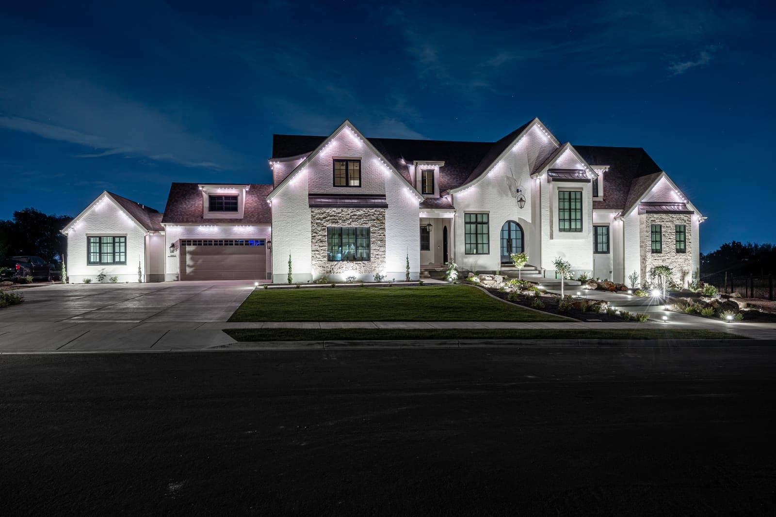 A home exterior brightly lit in white by roofline lighting at night.